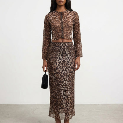 Woman in leopard-print outfit holding a small black bag.