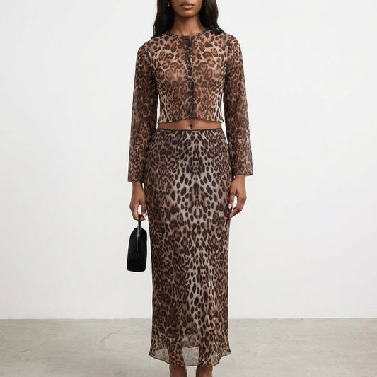 Woman in leopard-print outfit holding a small black bag.
