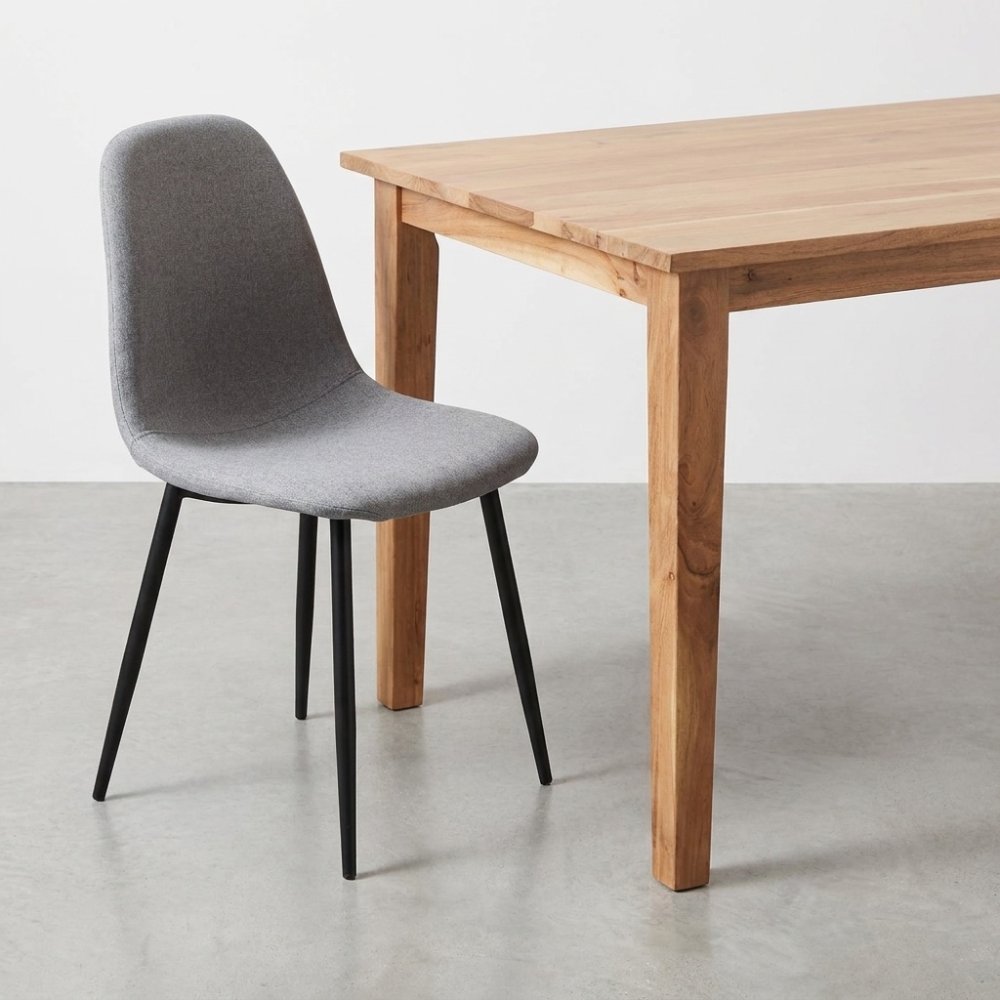 Gray chair next to a wooden table on a concrete floor.