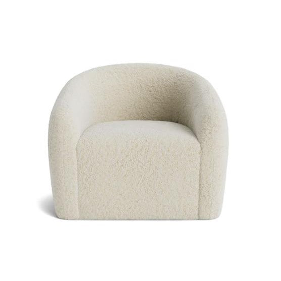 Cream-colored, fuzzy, modern armchair with rounded backrest.