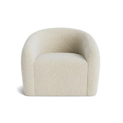 Cream-colored, fuzzy, modern armchair with rounded backrest.