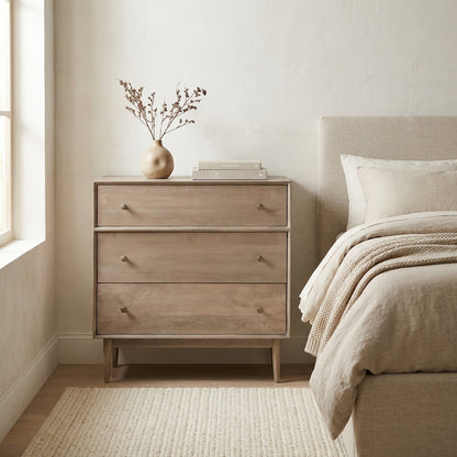 Wooden dresser with three drawers and round knobs, standing on angled legs.