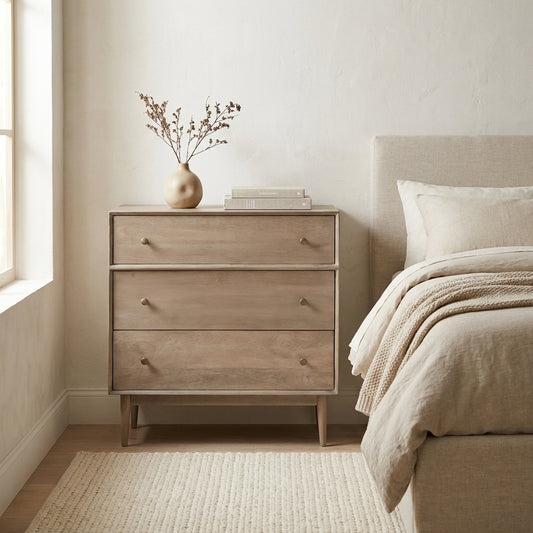 Wooden dresser with three drawers and round knobs, standing on angled legs.