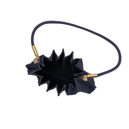 A pleated black handbag with a gold-accented handle.