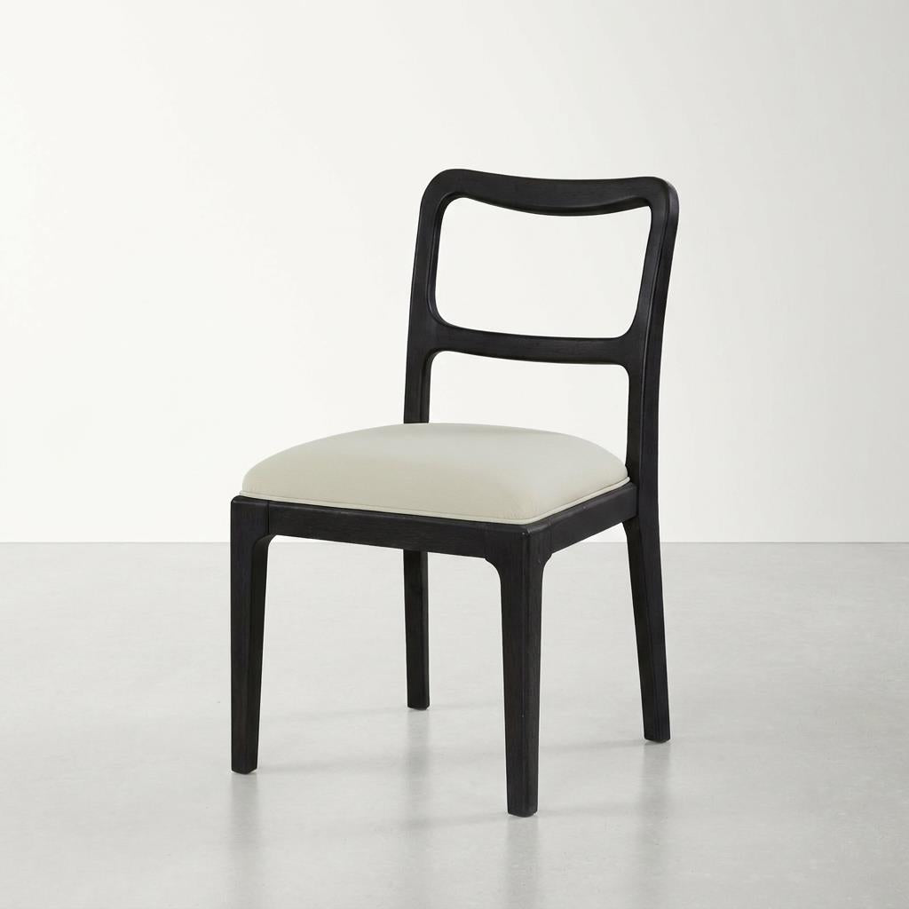 Modern black chair with a white cushioned seat on a plain background.
