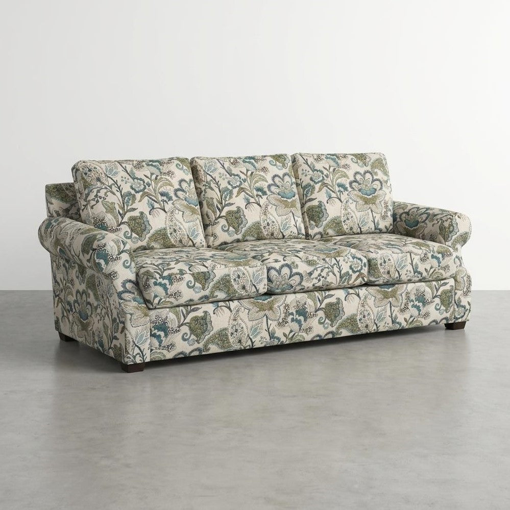 Floral-patterned sofa with a white background in a minimalist setting.