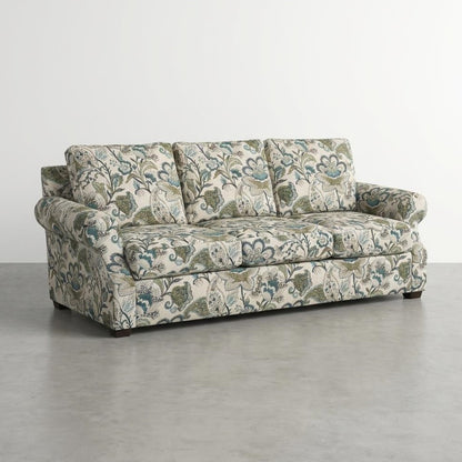 Floral-patterned sofa with a white background in a minimalist setting.
