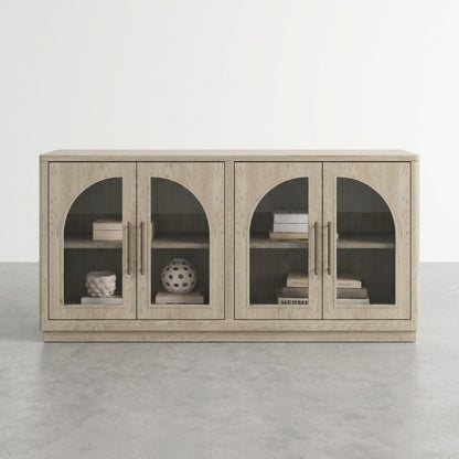 A light wood cabinet with arched glass doors displays books and decorative objects.