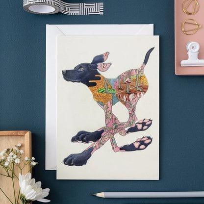 Colorful dog illustration on a card with stationery items.