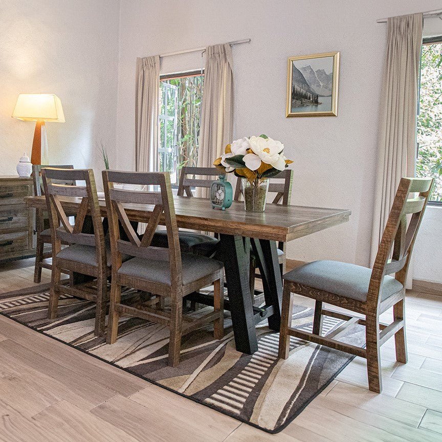 Bright dining room with wooden table, chairs, and floral centerpiece.
