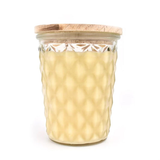 Textured glass jar with a wooden lid, filled with a creamy substance.