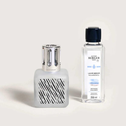 Decorative fragrance lamp and refill bottle on a light background.