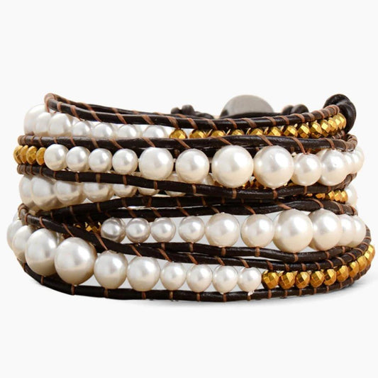 Layered pearl and gold bead bracelet on leather strands.