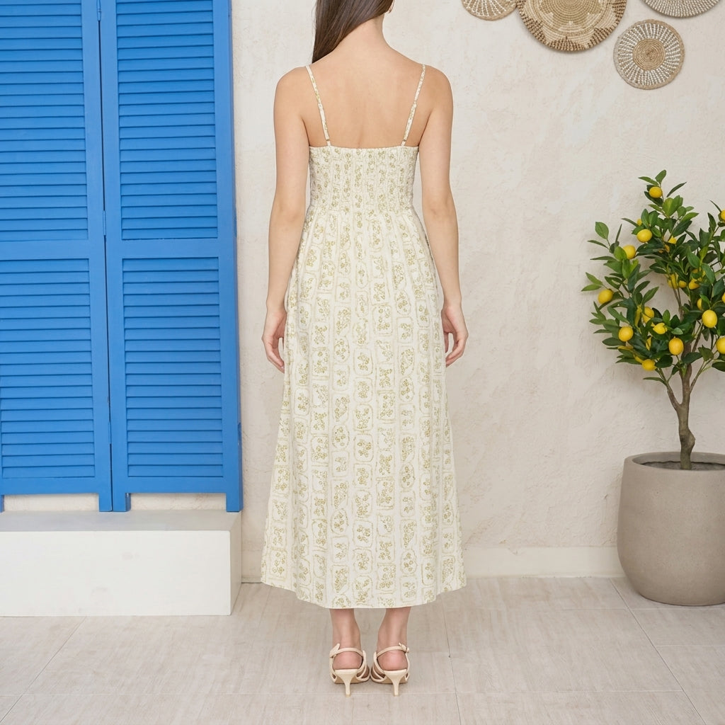 Woman in floral dress by blue door, lemon tree nearby.