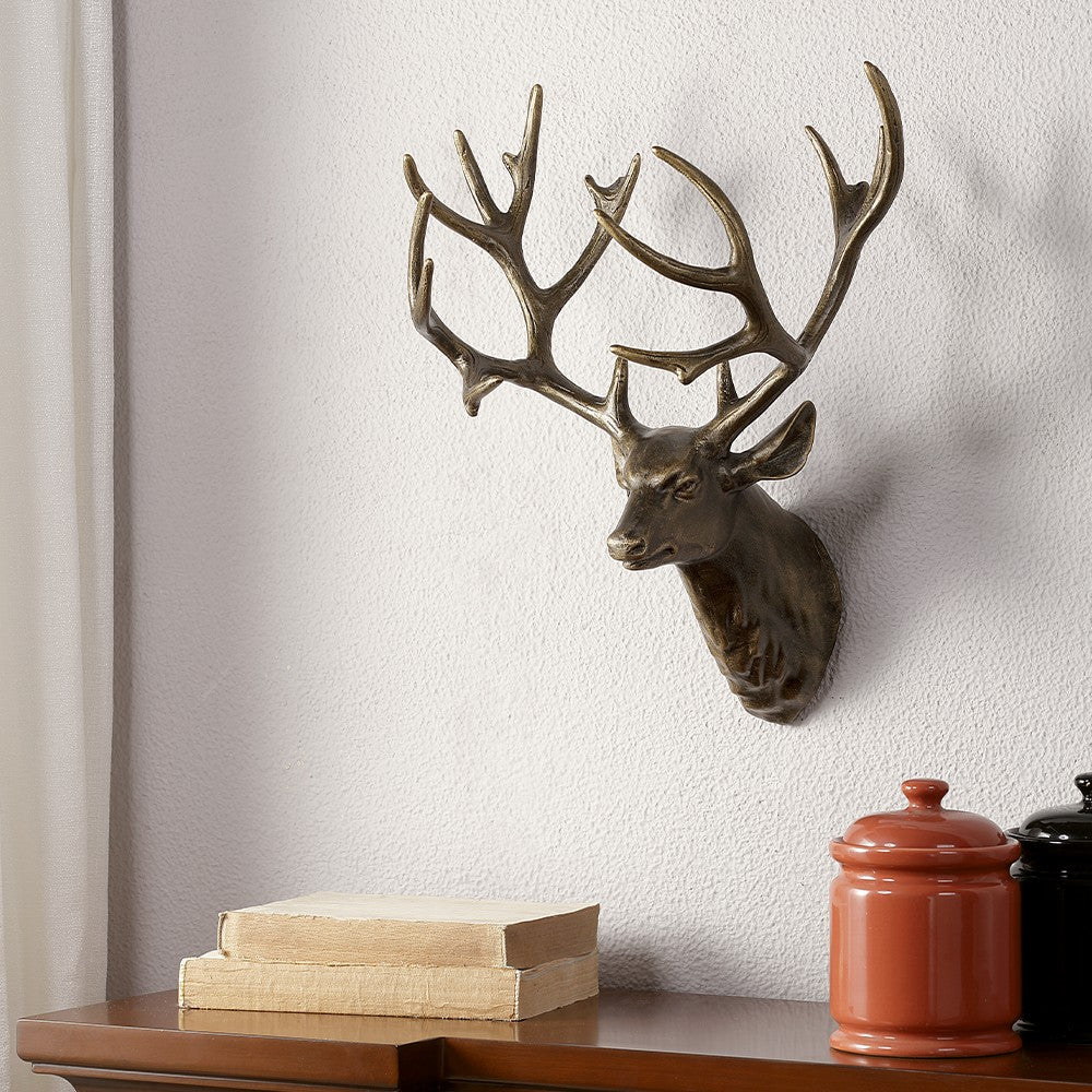 Deer head sculpture on wall above shelf with books and jars.