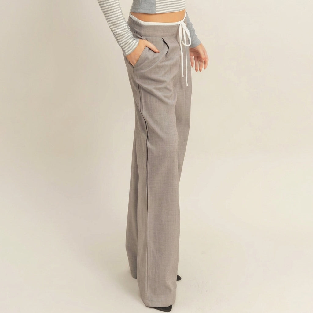 Person wearing gray high-waisted wide-leg pants with a striped crop top.