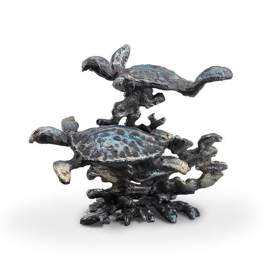 Metallic sculpture of two sea turtles swimming among coral.