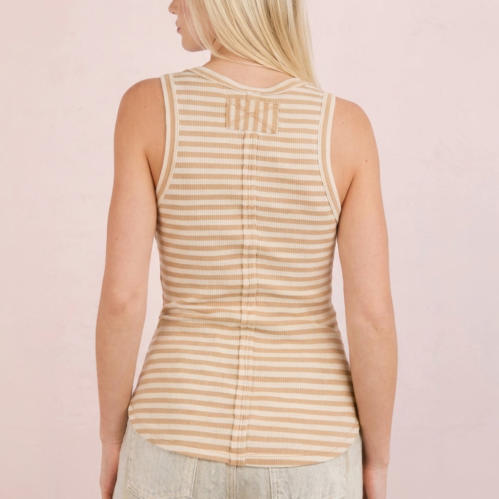 Blonde woman in a striped sleeveless top, shown from the back.