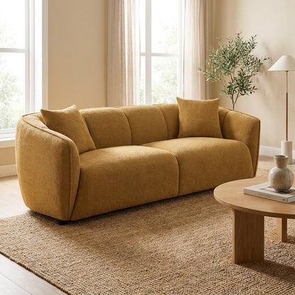 Cozy beige sofa in a sunlit room with minimalist decor.