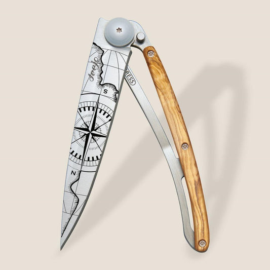 Folding knife with wooden handle and engraved blade with compass design.