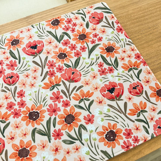 Floral-patterned fabric on a wooden table surface.