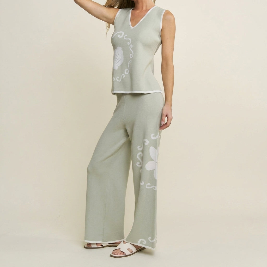 Woman in sage-green outfit with floral patterns, wearing sandals.