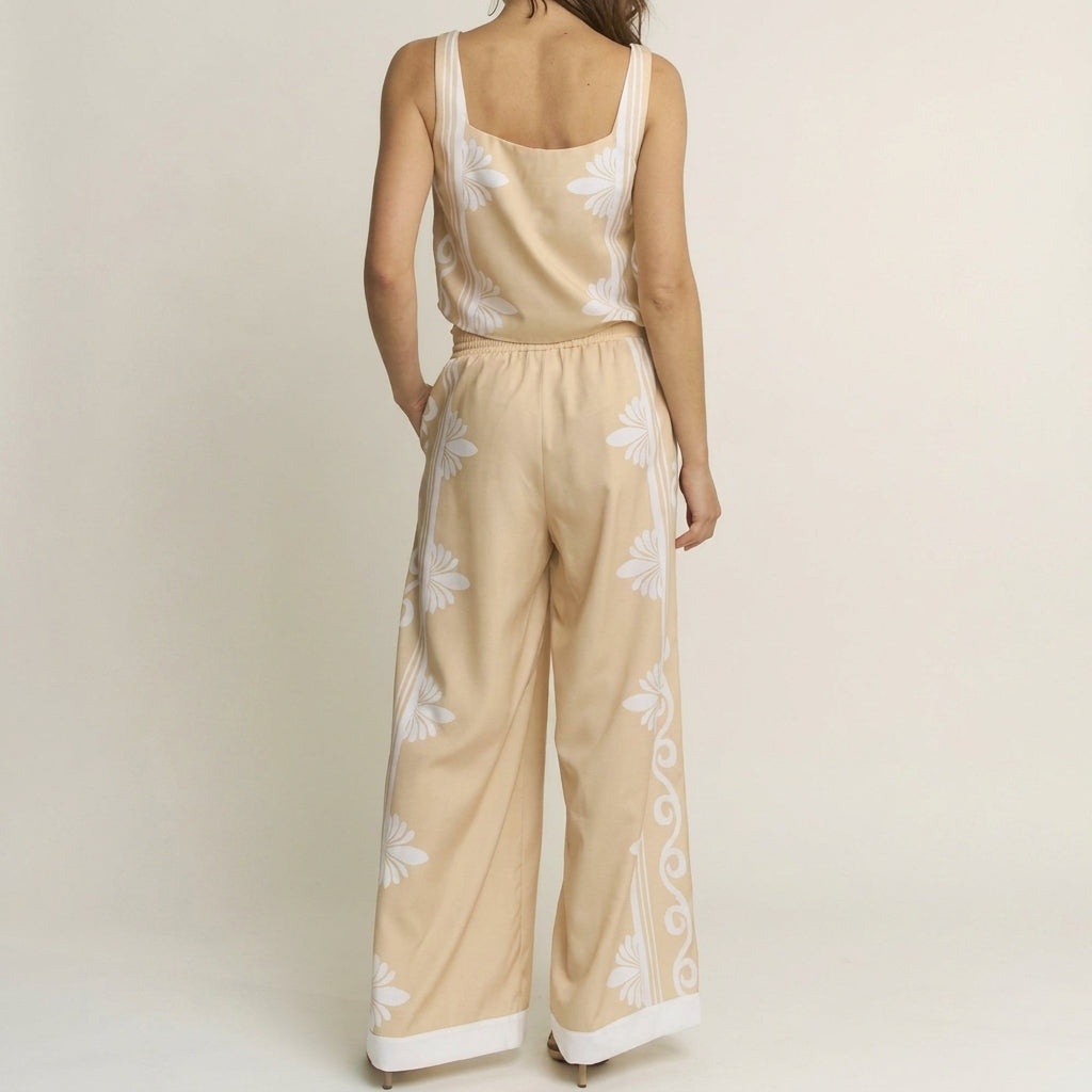 Woman in a floral beige jumpsuit, facing away.