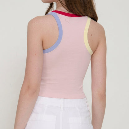 Person wearing a colorful tank top and white pants, shown from the back.