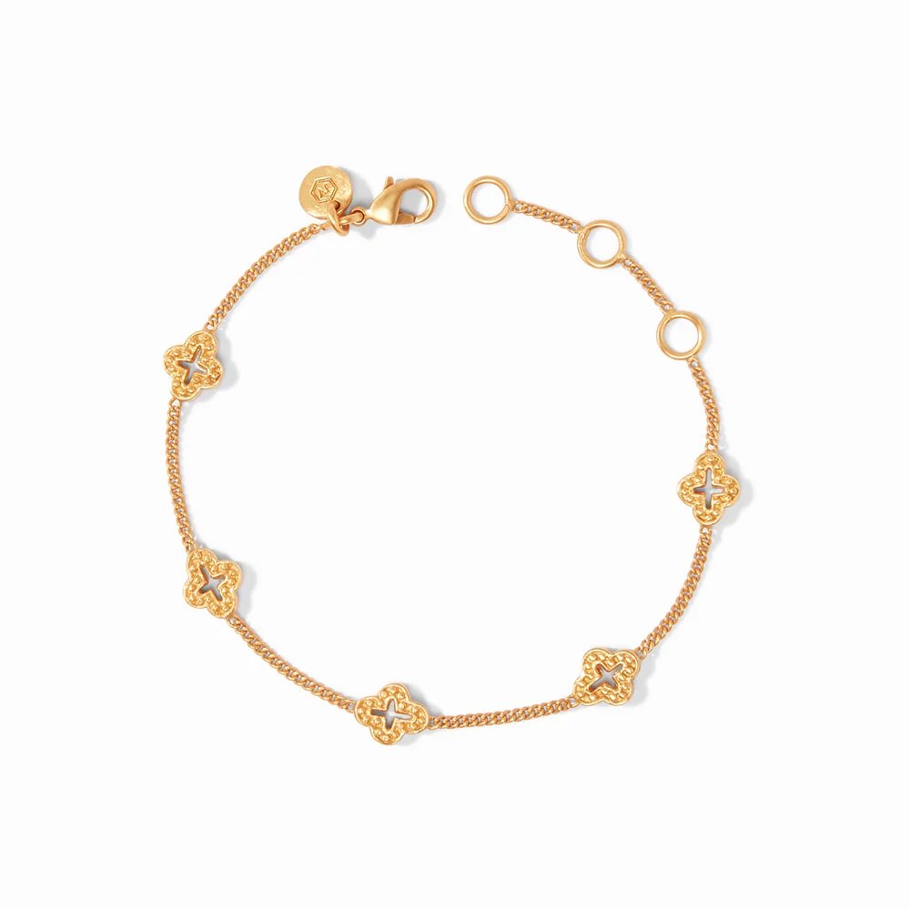 A delicate gold chain bracelet adorned with clover-shaped charms and circular links.
