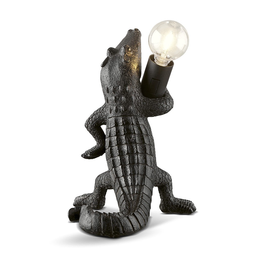 A crocodile-shaped lamp holding a light bulb.