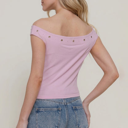 Woman in a pink off-shoulder top and blue jeans, facing away.