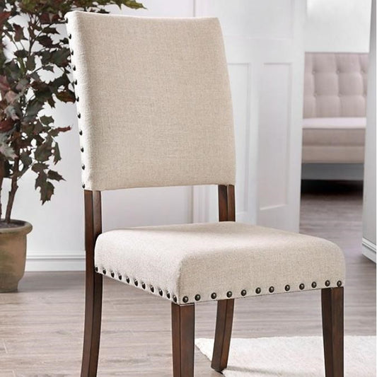 Beige upholstered chair with studded trim, wooden legs, indoors.