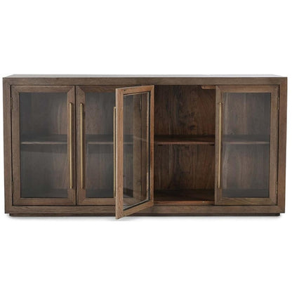 Wooden sideboard with books, plants, and art on a wall. Cozy and elegant decor.