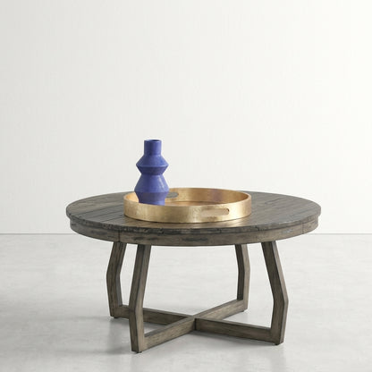 Round table with gold tray and blue vase on top.