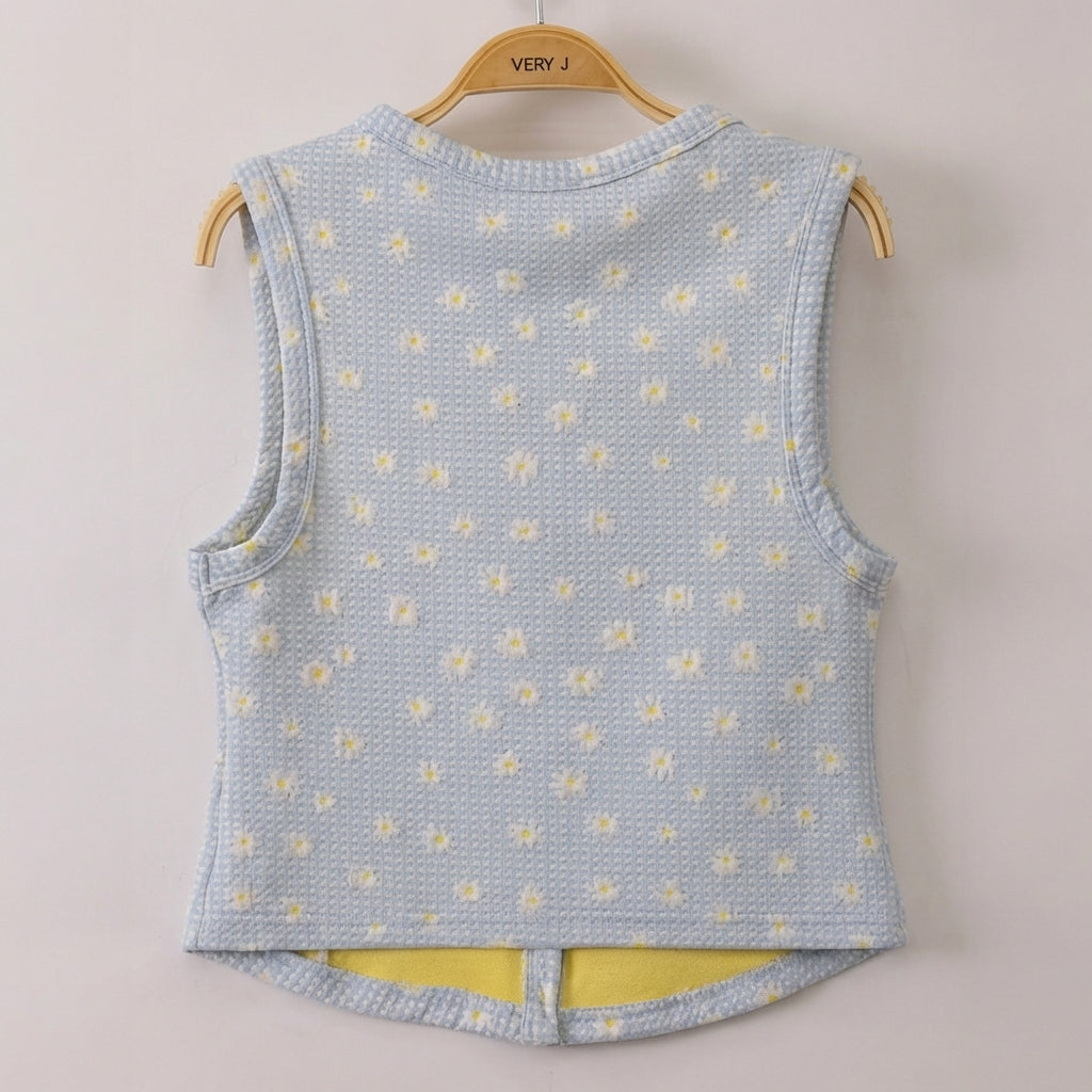 Light blue sleeveless vest with white and yellow floral print on a hanger.