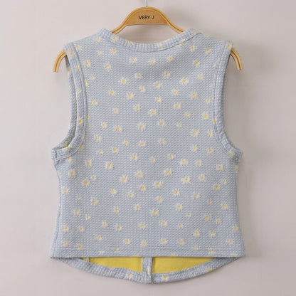 Light blue sleeveless vest with white and yellow floral print on a hanger.