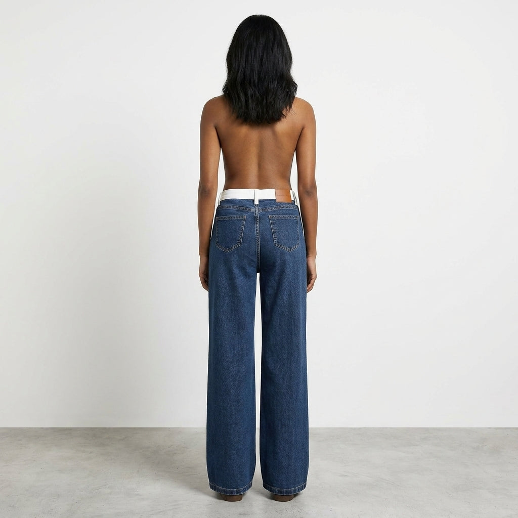 Back view of person in wide-leg jeans against a plain background.