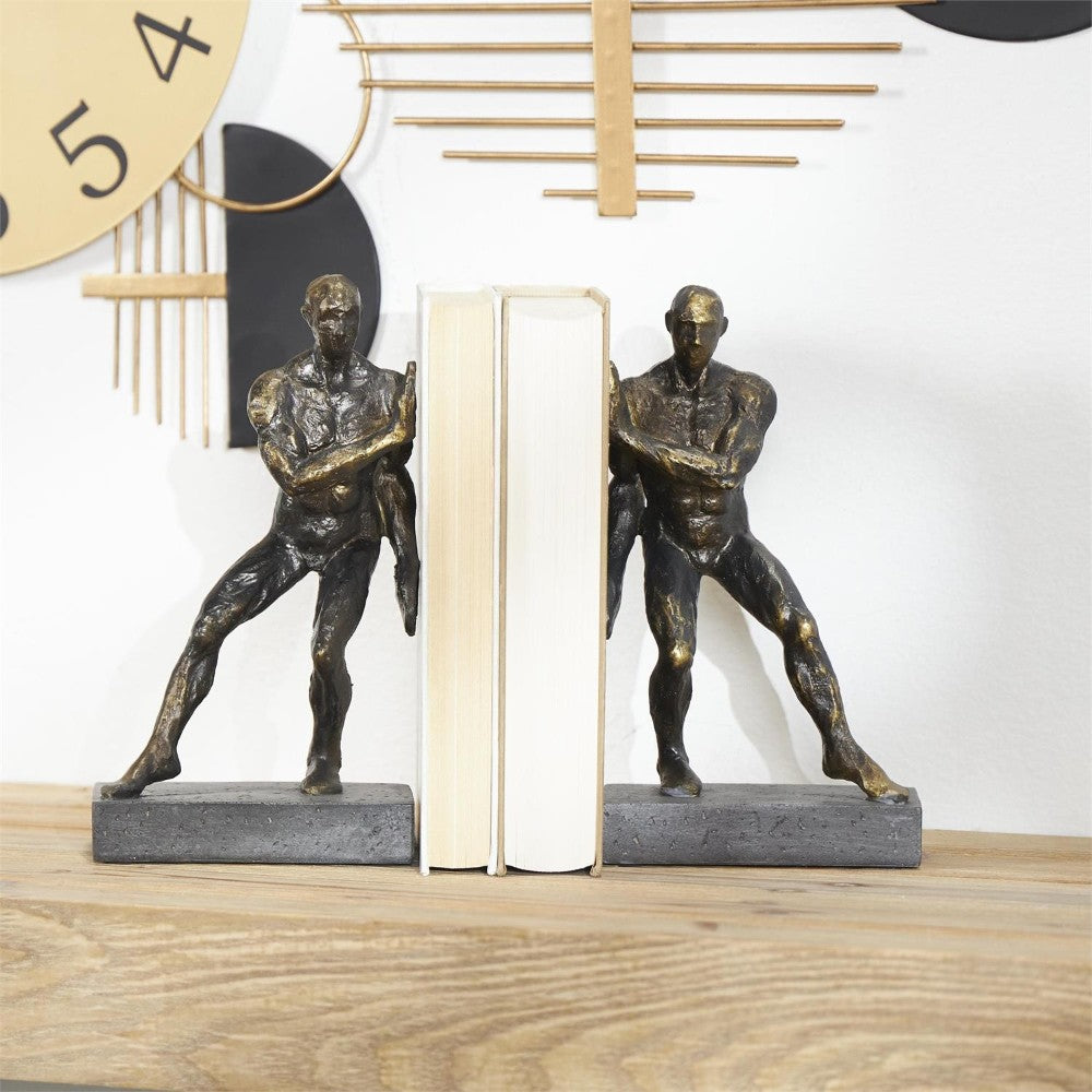 Two sculpted bookends holding books, with a modern wall clock behind.