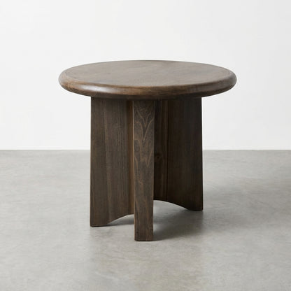 Dark wooden round side table on a gray floor.
