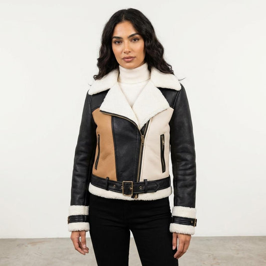 A woman models a black, tan, and cream shearling-trimmed jacket against a plain background.