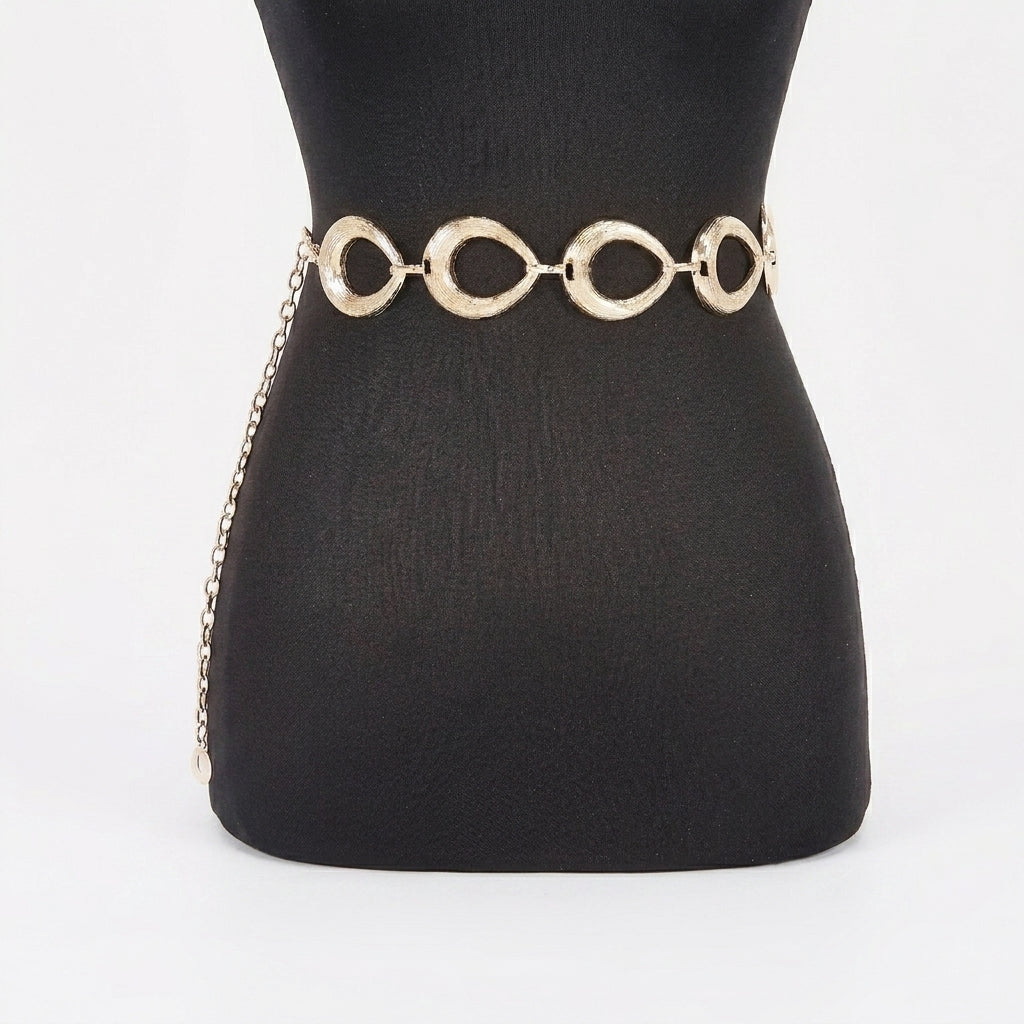 Gold chain belt on a black mannequin.