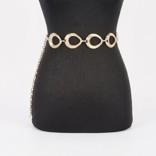 Gold chain belt on a black mannequin.