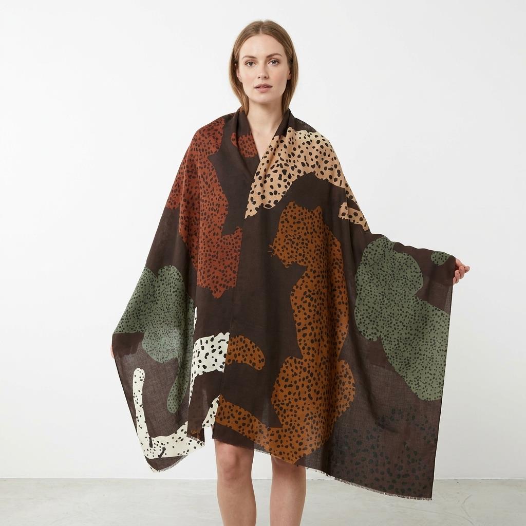 Person wearing a patterned, colorful shawl, standing indoors.