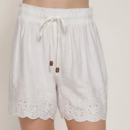 White lace-trimmed shorts with elastic waist and drawstring.