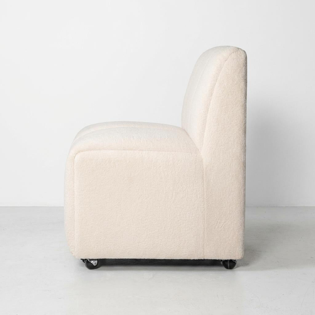 Creamy white chair with wheels, side view.