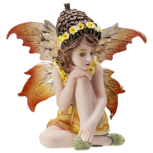 Fairy figurine with wings and floral crown, sitting with a thoughtful expression.