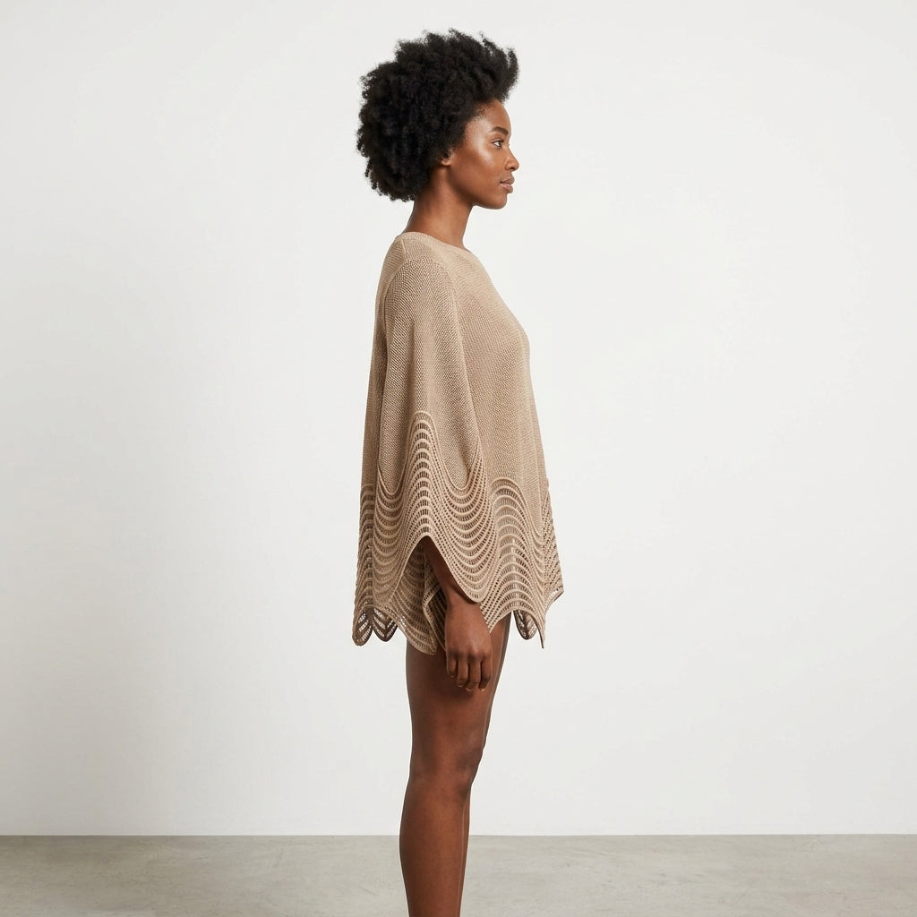 Person in profile wearing a beige poncho, standing against a plain background.