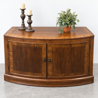 Wooden cabinet with two candles and a potted plant on top.