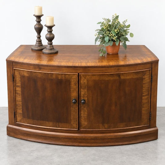 Wooden cabinet with two candles and a potted plant on top.