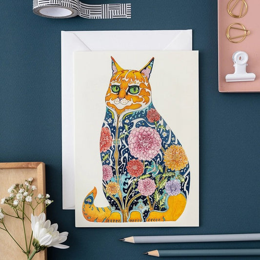 Colorful cat art with floral patterns beside stationery items.